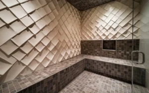 Modern walk-in shower with textured wall tiles and mosaic tile flooring.