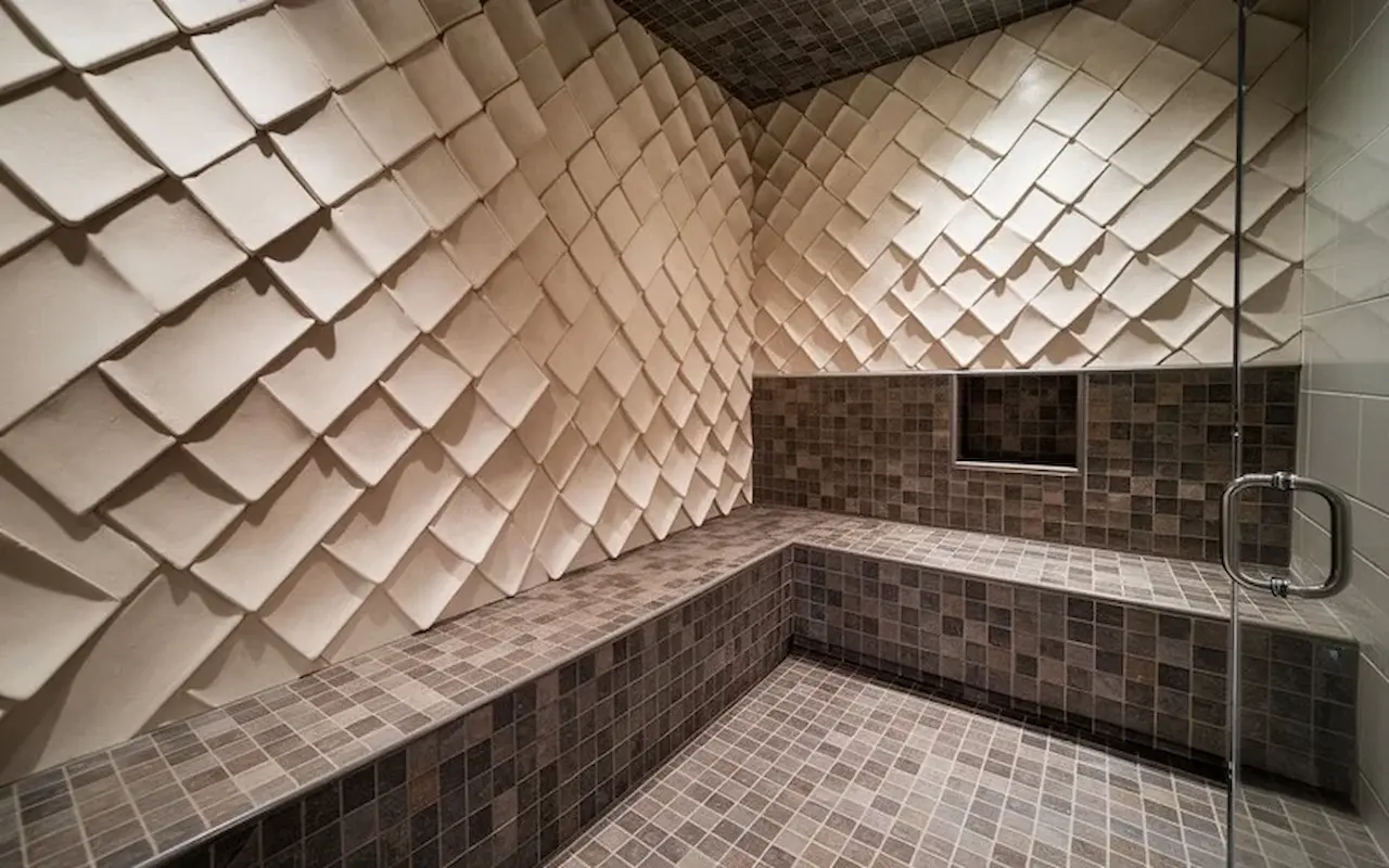 Modern walk-in shower with textured wall tiles and mosaic tile flooring.